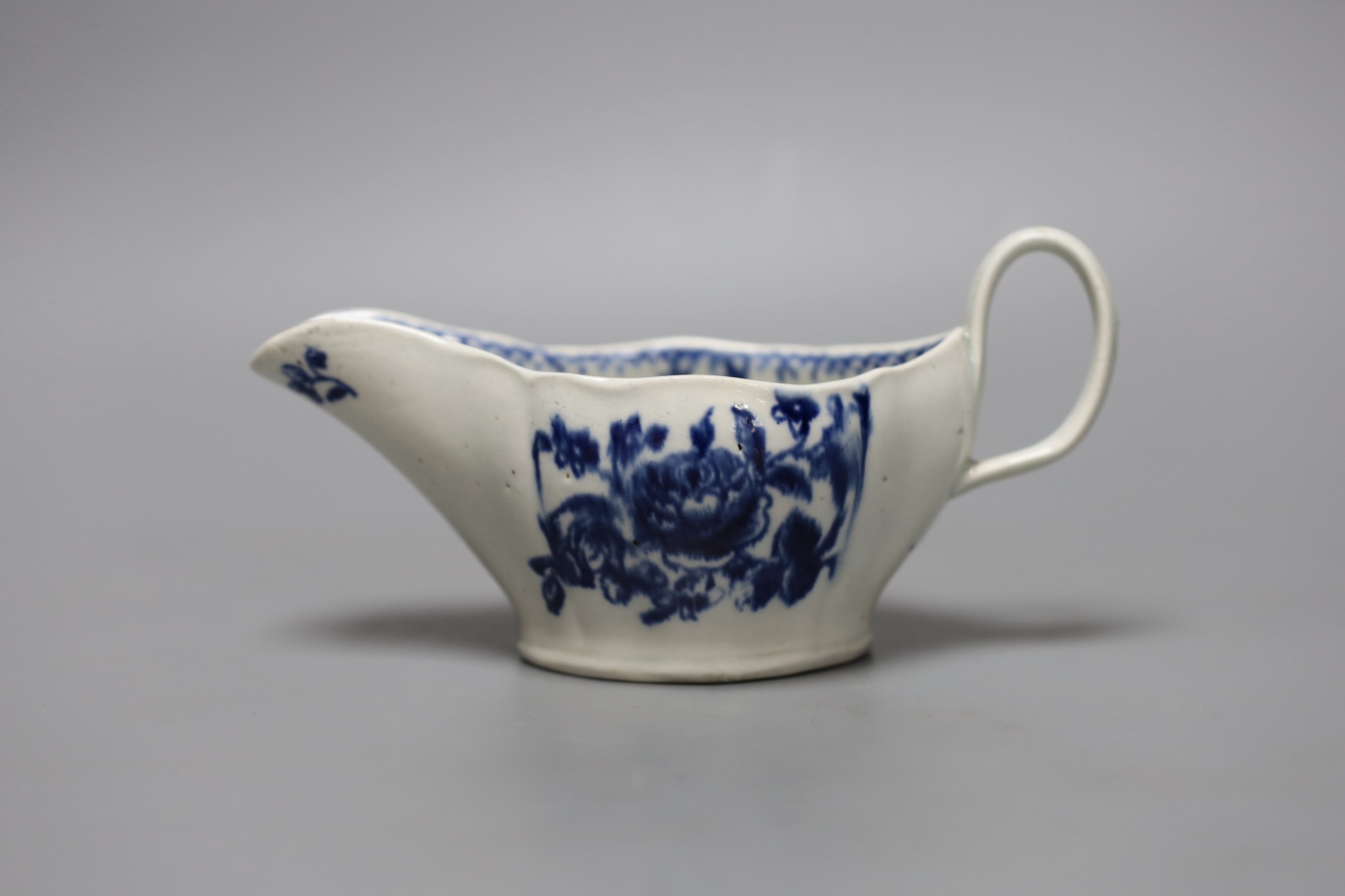 A Liverpool sauceboat decorated in blue underglaze flowers, the interior with further flowers and a dot and loop border, 16cm long
